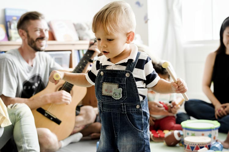 Scuola materna progetto musica: bambino gioca con strumenti